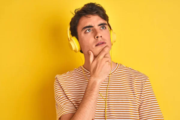 Niño Adolescente Con Auriculares Sobre Fondo Amarillo Aislado Con Mano — Foto de Stock