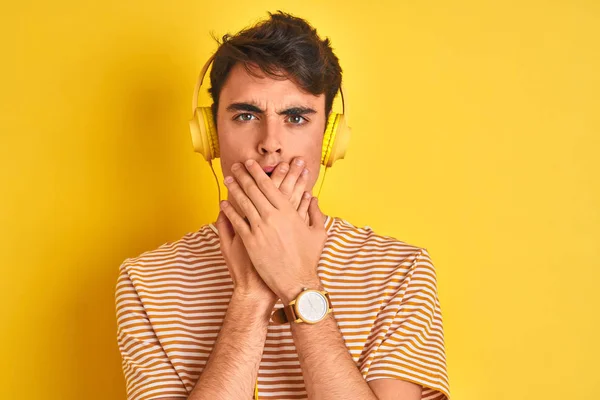 Adolescente Niño Usando Auriculares Sobre Fondo Amarillo Aislado Impactado Cubriendo — Foto de Stock