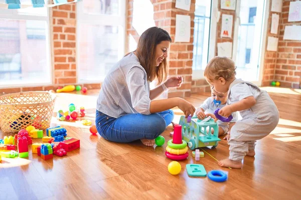Schöne Lehrerin Und Kleinkinder Spielen Kindergarten Mit Viel Spielzeug — Stockfoto