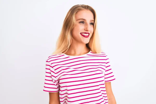 年轻美丽的女人穿着粉色条纹T恤 站在孤零零的白色背景上 面带微笑地望着旁边 自然的表情 充满自信的笑 — 图库照片