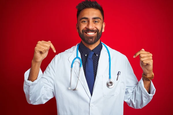 청진기를 인도의 의사가 얼굴에 미소를 머금고 자랑스럽고 손가락으로 자신을 가리키며 — 스톡 사진