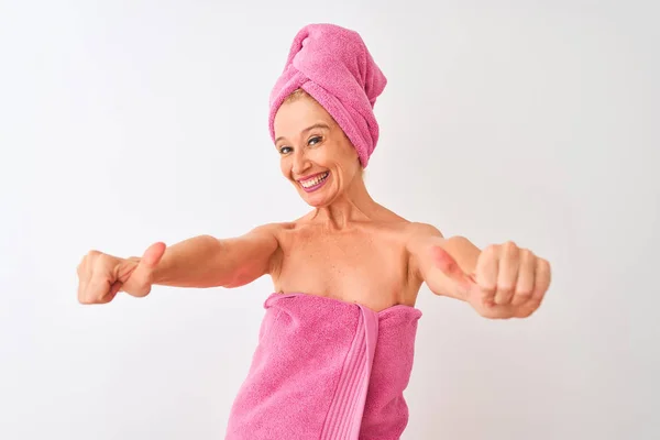 中年妇女洗完澡后穿着浴巾站在孤立的白色背景上 赞成用手做积极的手势 微笑着竖起大拇指 为成功感到高兴 赢的手势 — 图库照片