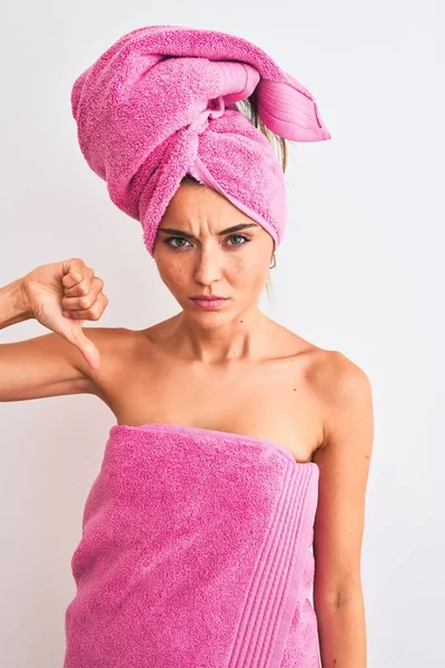 年轻漂亮的女人洗完澡后穿着浴巾披着孤立的白色背景 满脸怒容 消极的迹象表明她不喜欢大拇指朝下 拒绝的观念 — 图库照片