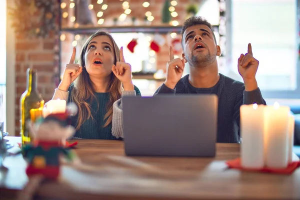 Junges Schönes Paar Sitzt Mit Laptop Weihnachtsdekoration Hause Erstaunt Und — Stockfoto