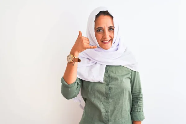 孤立した背景の上に伝統的なイスラム教徒のヒジャーブを身に着けている若い美しいアラブの女性は 電話で話すような手と指で電話ジェスチャーをして笑っています 概念の伝達 — ストック写真