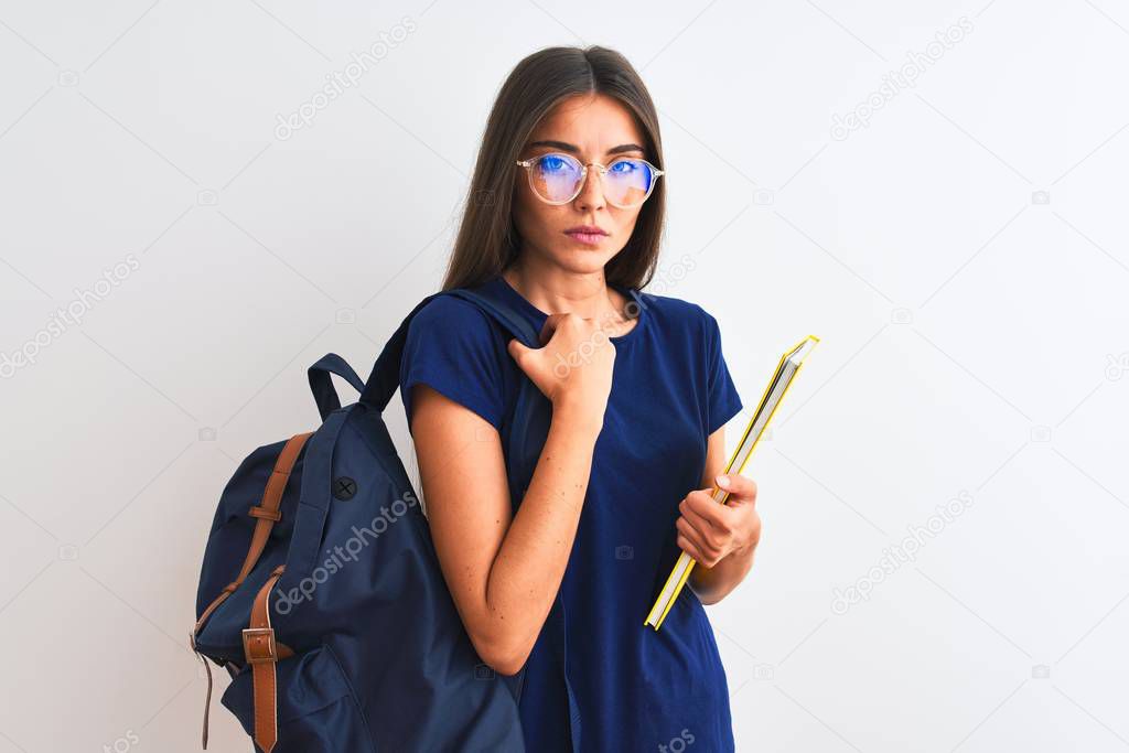 Young student woman wearing backpack glasses holding book over isolated white background with a confident expression on smart face thinking serious