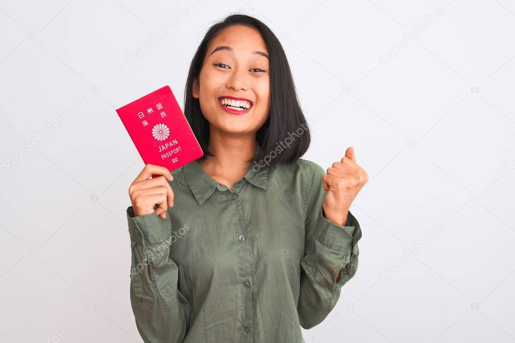 Beautiful chinese woman holding Japan Japanese passport over isolated white background screaming proud and celebrating victory and success very excited, cheering emotion