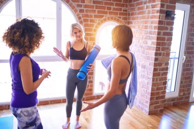 Mutlu gülümseyen genç ve güzel bir sporcu grubu. Beden dersinde yoga dersinden önce ayakta konuşma.