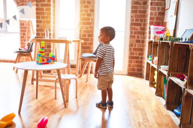 Anaokulunda bir sürü oyuncakla bekleyen güzel bir çocuk.