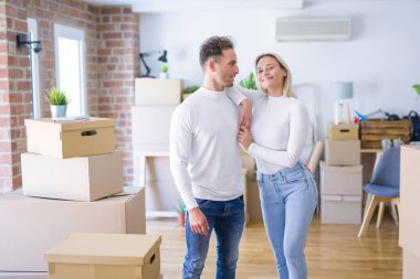 Karton kutuların etrafında duran genç ve güzel bir çift.