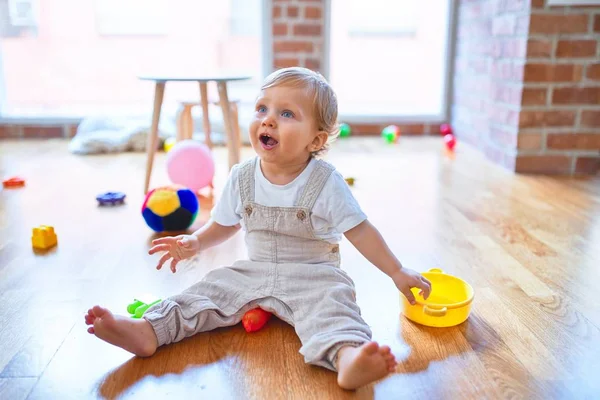 Sevimli Sarışın Çocuk Gülümsüyor Anaokulunda Bir Sürü Oyuncağın Etrafında Mutlu — Stok fotoğraf