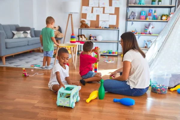Junge Schöne Lehrerin Und Kleinkinder Spielen Kindergarten Mit Viel Spielzeug — Stockfoto