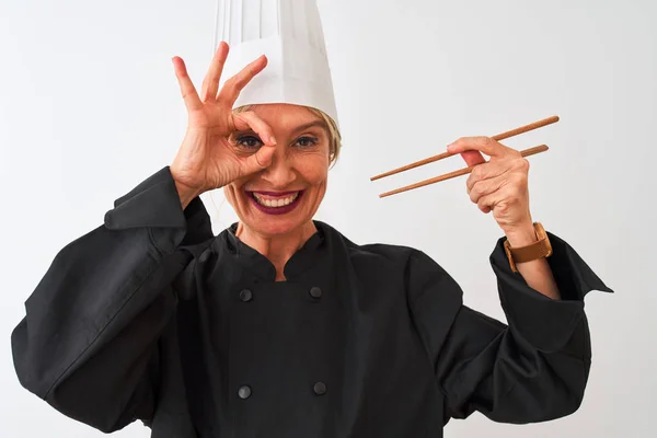 中年厨师 头戴帽子 头戴筷子 面带微笑 在孤立的白色背景上 手拿着筷子 手拿着手拿着手签 透过手指看 — 图库照片