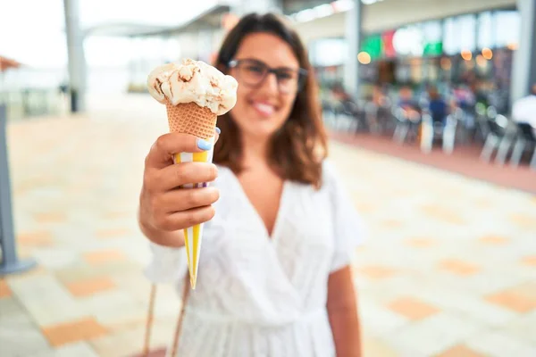 若いです美しい女性食べるアイスクリームコーンでショッピングセンターで夏の晴れた日に休日 — ストック写真
