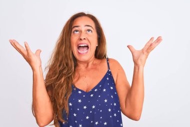 Orta yaşlı olgun bir kadın, beyaz arka planda duruyor. Kızgın ve deli gibi bağırıyor, agresif bir ifadeyle bağırıyor ve kollarını kaldırıyor. Hayal kırıklığı konsepti.