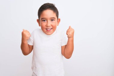 Güzel çocuk, izole edilmiş beyaz arka plan üzerinde dikilmiş kollarını kaldırarak ve açık gözlerle başarıyı kutluyor ve şaşırıyor. Kazanan konsept.