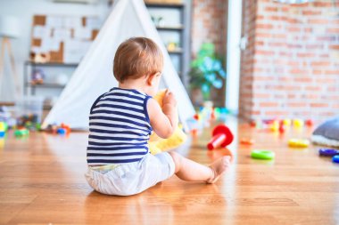 Anaokulunda bir sürü oyuncakla oynayan sevimli bir çocuk.