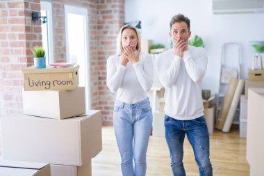 Karton kutuların etrafında duran genç ve güzel bir çift yanlışlıkla ağızlarını kapatarak şok geçirdiler. Gizli konsept.