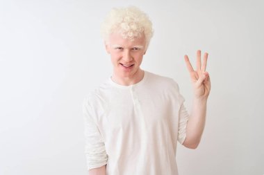 Ayrı beyaz arka plan üzerinde duran ve kendinden emin ve mutlu bir şekilde gülümseyen genç albino sarışın adam üç numarayı işaret ediyor..