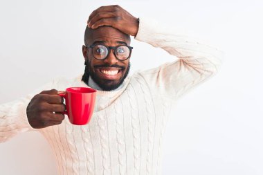 Saçları örgülü Afrikalı Amerikalı bir adam izole edilmiş beyaz arka planda kahve içiyor. Elleri başının üstünde, utanç ve şaşkınlık dolu, sinirli ve hayal kırıklığına uğramış bir halde. Hata için korku ve üzüntü.