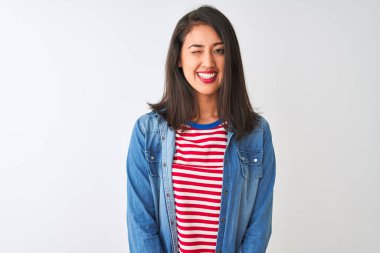 İzole edilmiş beyaz arka plan üzerinde çizgili tişört ve kot giyen genç Çinli kadın kameraya seksi bir ifadeyle bakıyor, neşeli ve mutlu bir yüzle..