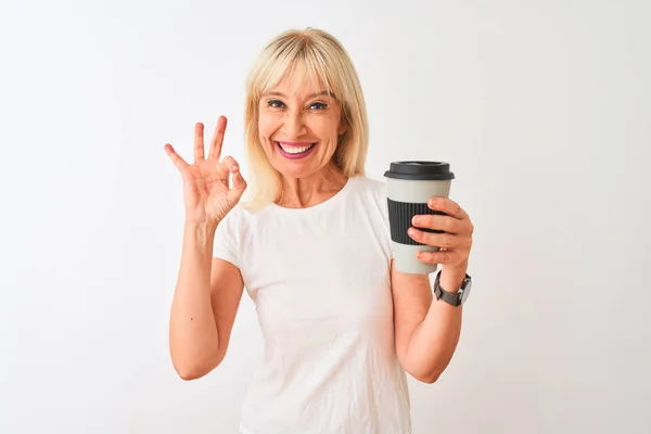 中年妇女喝着一杯带走的咖啡 站在孤零零的白色背景上 手握手签 很好的象征 — 图库照片