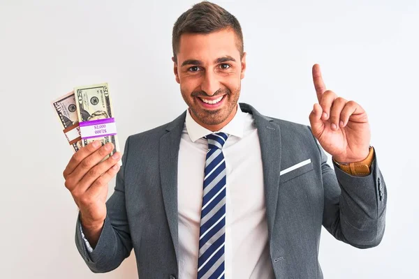 Młody Przystojny Biznesmen Trzymający Kilka Dolarów Banknotów Odosobnionym Tle Zaskoczony — Zdjęcie stockowe