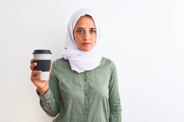 Geleneksel Müslüman başörtüsü takan genç, güzel bir Arap kadın. Zeki bir yüz ifadesiyle kahve içiyor. Ciddi düşünüyor.