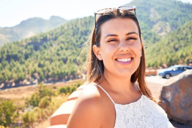Genç ve güzel bir turist kadın gülümsüyor. Yaz tatilinin tadını çıkarıyor.
