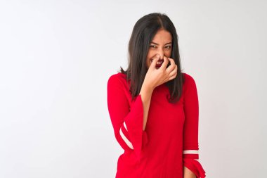 İzole edilmiş beyaz arka planda kırmızı elbise giyen genç, güzel Çinli bir kadın pis ve iğrenç bir koku alıyor. Nefesini burnunda tutuyor. Kötü koku konsepti.