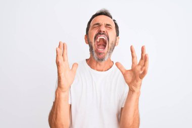 Orta yaşlı yakışıklı bir adam, izole edilmiş beyaz arka plan üzerinde dikilmiş sinirli sinirli sinirli bağırıyor ve agresif bir ifade ve kollarla bağırıyor. Hayal kırıklığı konsepti.