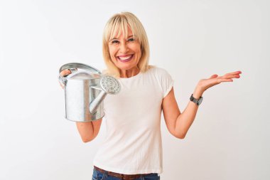 Orta yaşlı bahçıvan kadın su dolu teneke bir kutuda bekliyor mutlu ve heyecanlı, kazanan ifade zaferi kutluyor büyük bir gülümsemeyle ve el kaldırarak.