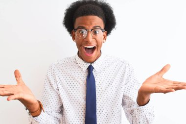 Genç Afrikalı Amerikalı iş adamı kravat takıp gözlük takarak çılgın ve hayret verici başarısını kutluyor ve kollarını kaldırıp heyecanla haykırıyor. Kazanan konsept