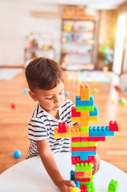 Güzel çocuk anaokulunda inşaat bloklarıyla oynuyor.