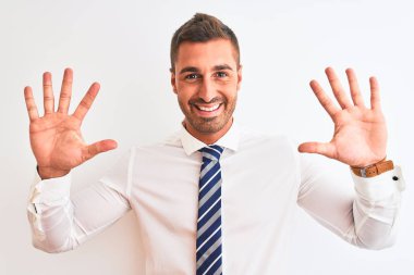 Genç yakışıklı, zarif iş adamı izole edilmiş arka planda on numarayı gösterip işaret ederken kendinden emin ve mutlu bir şekilde gülümsüyor..