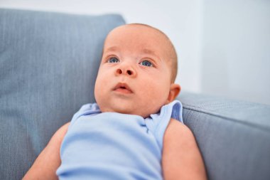 Evdeki kanepede uzanmış sevimli bir bebek. Yeni doğmuş bebek rahatlıyor ve dinleniyor.