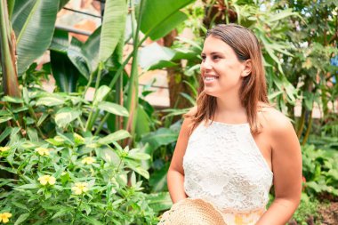 Güneşli bir yaz gününde, kelebek bahçesinde mutlu ve neşeli gülümseyen güzel bir kadın.