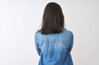 İzole edilmiş beyaz arka plan üzerinde çizgili t-shirt ve kot gömlek giyen genç Çinli kadın geriye doğru çapraz kollarla bakıyor.
