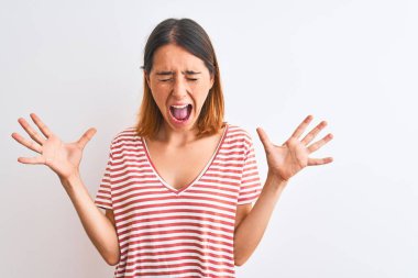 Güzel kızıl saçlı kadın, izole edilmiş arka plan üzerine sıradan kırmızı tişört giyip başarıyı kutluyor. Kolları havada, gözleri kapalı, heyecanlı çığlıklar atıyorlar. Kazanan konsept