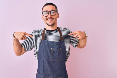Çalışan önlüğü takan genç, izole edilmiş bir geçmişi olan, kendine güvenen, kendini gururlu ve mutlu gösteren bir adam..