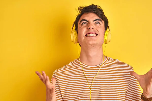 Niño Adolescente Con Auriculares Sobre Fondo Amarillo Aislado Loco Loco — Foto de Stock