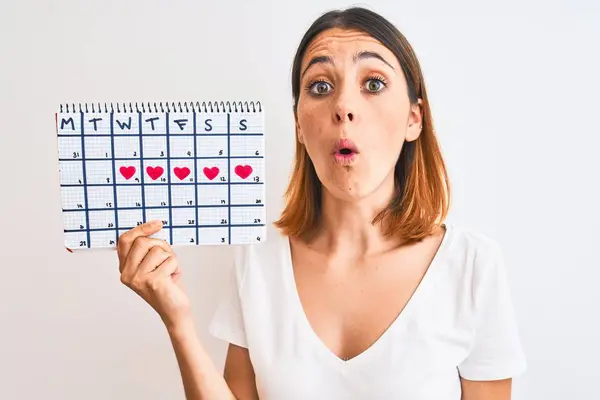 Hermosa Pelirroja Sosteniendo Calendario Menstruación Sobre Fondo Aislado Asustada Shock —  Fotos de Stock