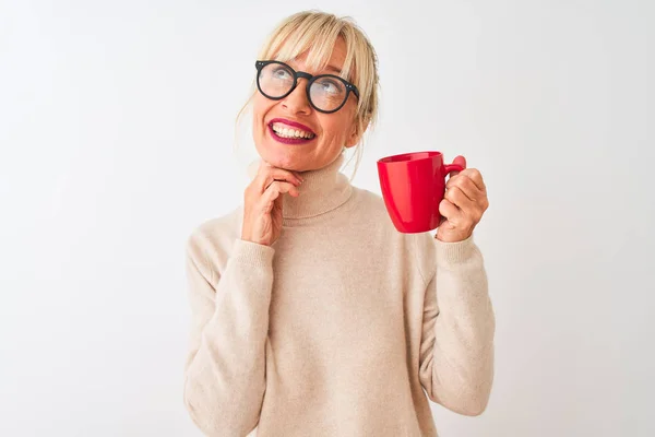 中年妇女戴着眼镜 在与世隔绝的白色背景下喝着红杯咖啡 严肃地思考着问题 非常混乱的想法 — 图库照片