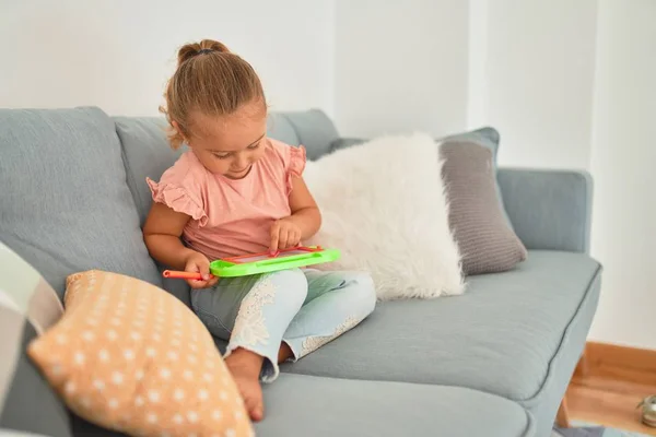 Schöne Blonde Kleinkind Mädchen Sitzt Auf Dem Sofa Zeichnung Mit — Stockfoto