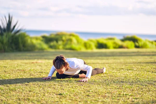 年轻美丽的女运动员练习瑜伽 教练在公园教狗狗仰面姿势 — 图库照片