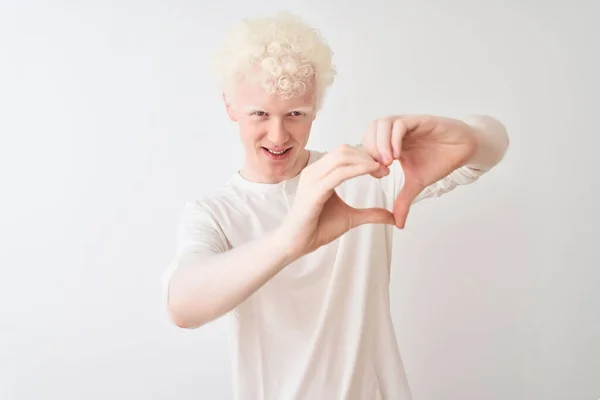 年轻的白化病金发男人穿着休闲装站在孤独的白色背景上 微笑着 用双手做着心形符号 浪漫的概念 — 图库照片