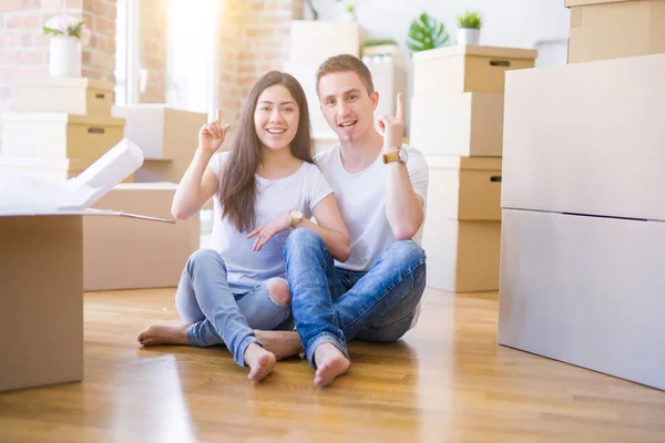 Young Beautiful Couple Sitting Floor New Home Cardboard Boxes Surprised — Stock Photo, Image