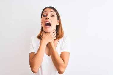 Güzel kızıl saçlı kadın, izole edilmiş arka planda günlük beyaz tişört giyip boğularak can çekişiyor çünkü boğularak can çekişiyor. Sağlık problemi. Boğulma ve intihar konsepti.