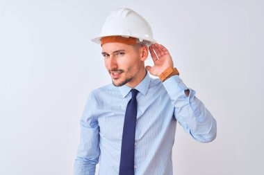 Müteahhit kaskı takan genç bir iş adamı izole edilmiş arka planda dedikodu ve dedikodulara kulak misafiri olarak gülümsüyor. Sağırlık kavramı.