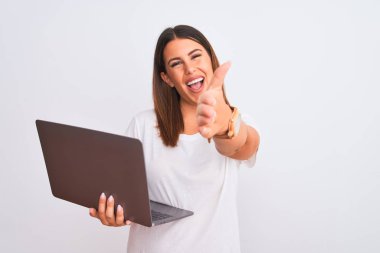 Güzel, genç bir kadın bilgisayarını beyaz arka plan üzerinde kullanıyor gülümseyerek selamlama ve hoş geldin demek için tokalaşıyor. Başarılı bir iş..